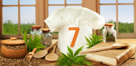 A chef cap with number 7, cook book, wooden spoon, cannabis seeds and leaves