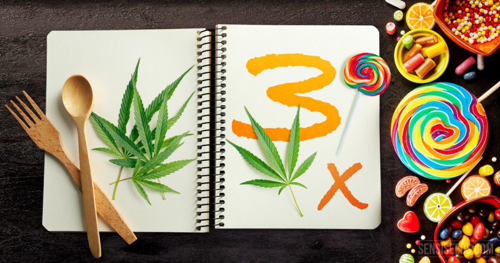 Un cahier avec des feuilles de cannabis et le numéro 3 et des bonbons à côté