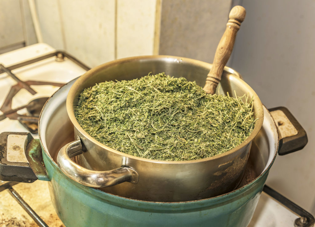 Slow cooker with herbs on a stove