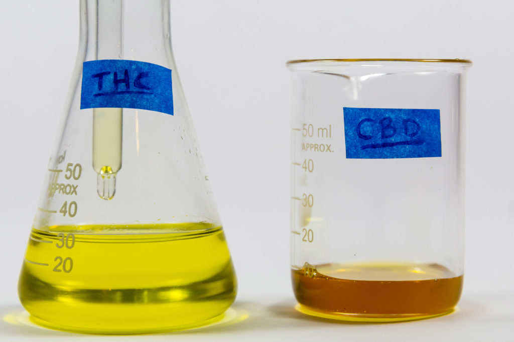 Two test tubes with liquids labeled as THC and CBD