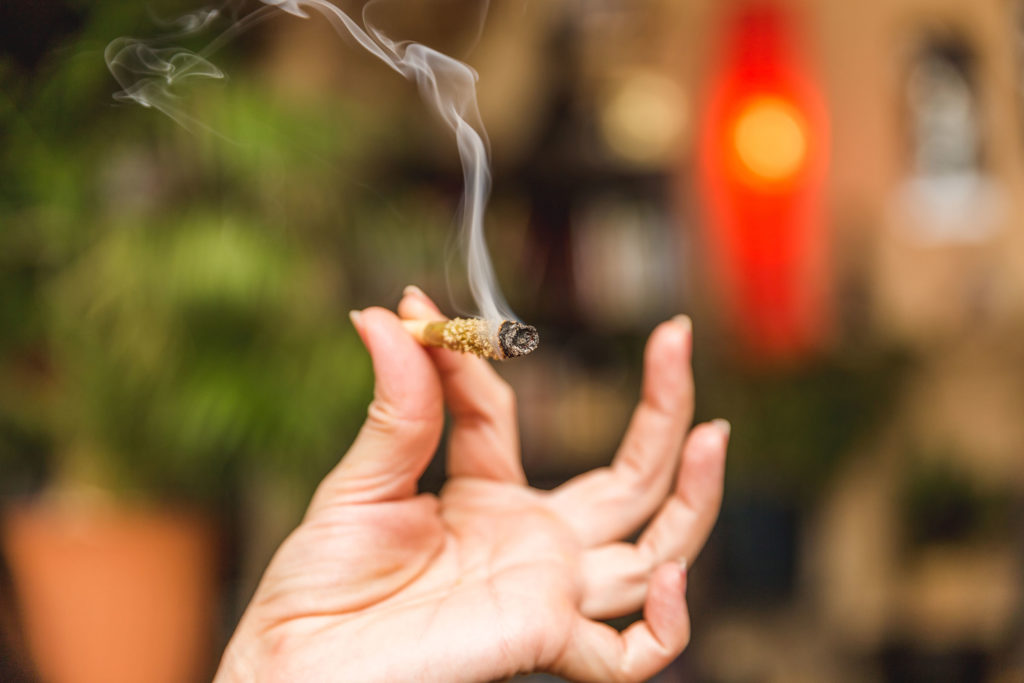 Eine Frau, die ein beleuchtetes Gelenk mit Kief hält