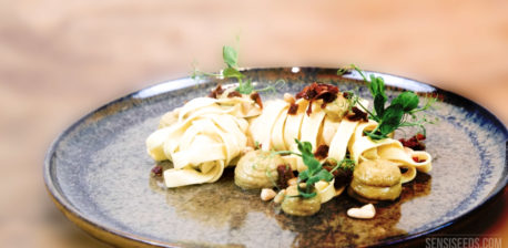 Tagliatelle met veganistische pastasaus en kruiden op een bord