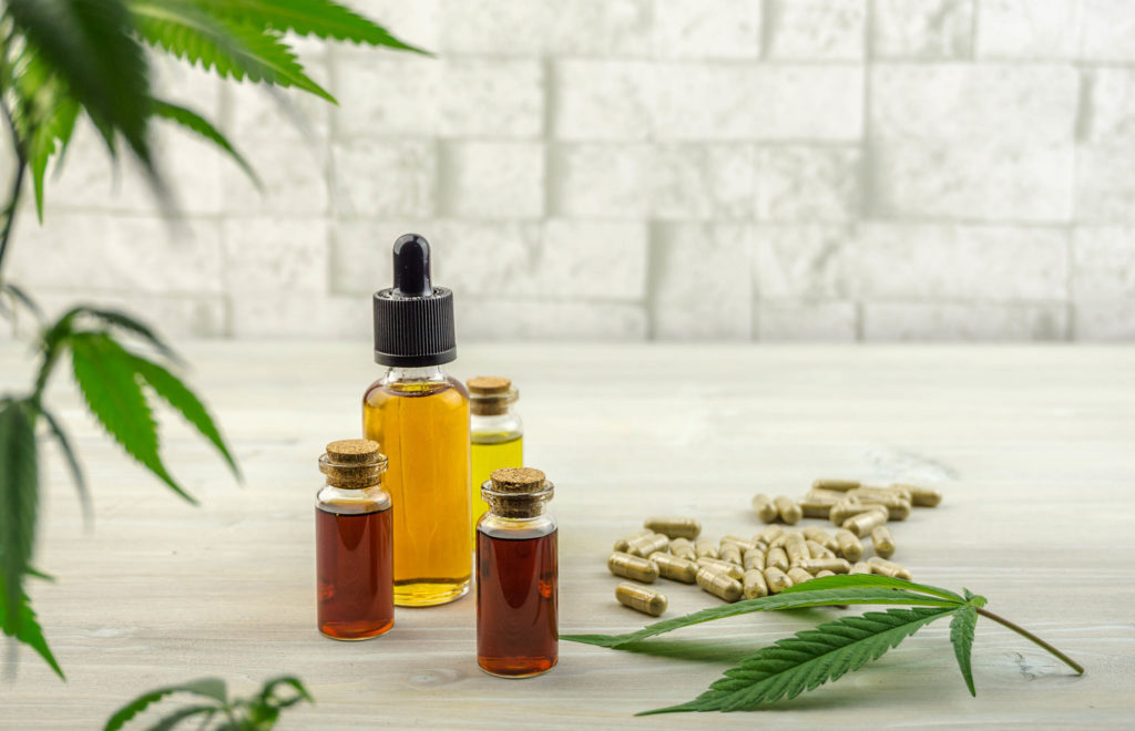 CBD oil bottles, CBD capsules and cannabis leaves