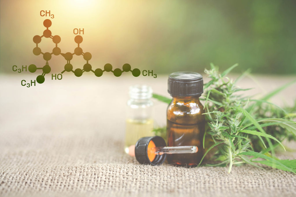 The chemical formula of CBD, two CBD oil bottles and a cannabis plant