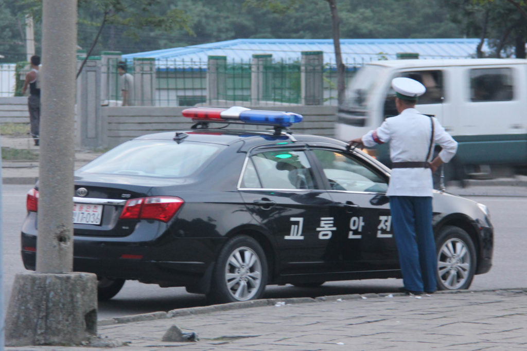 A police car on the street and a man in uniform