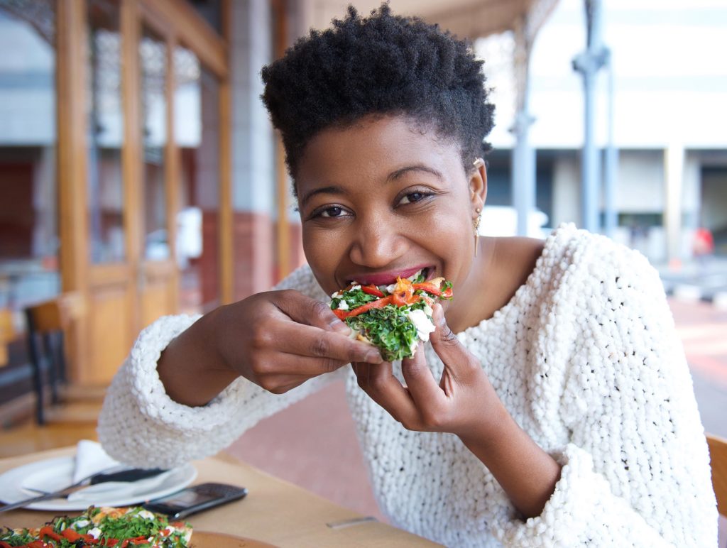 Een Afro-Amerikaanse vrouw die bruschetta eet