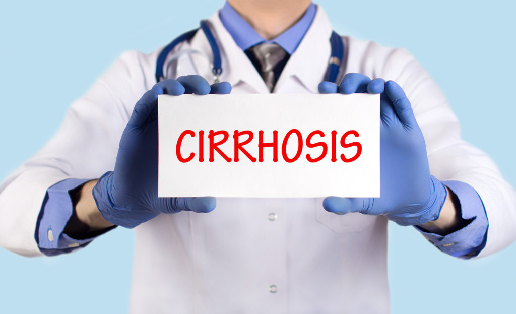 A doctor holding up a sign which says 'cirrhosis' in red letters