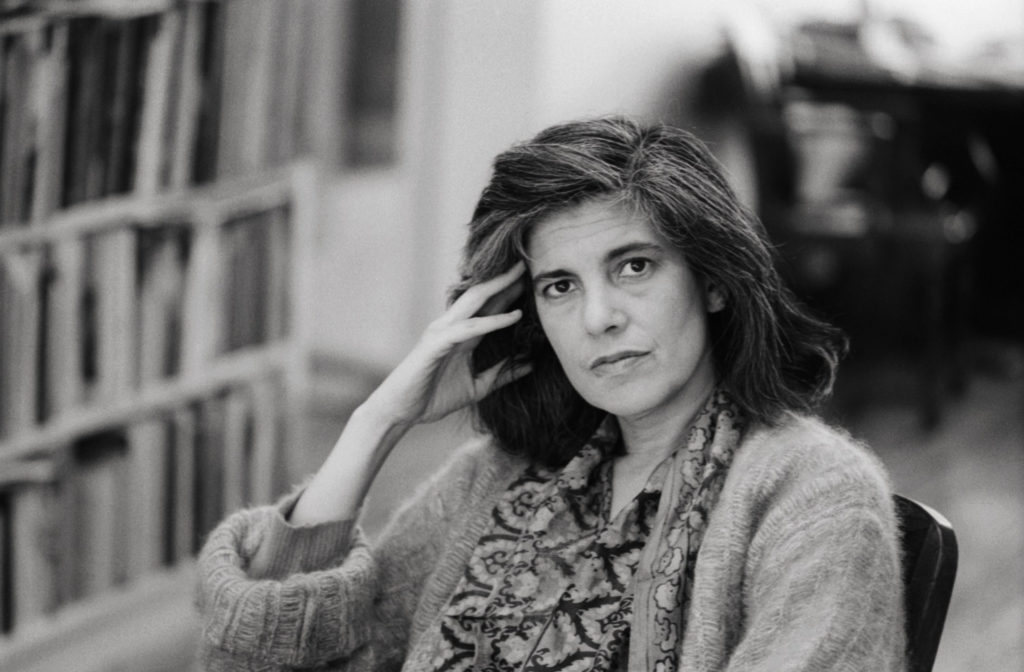 Susan Sontag sat on a chair and resting her head on her hand