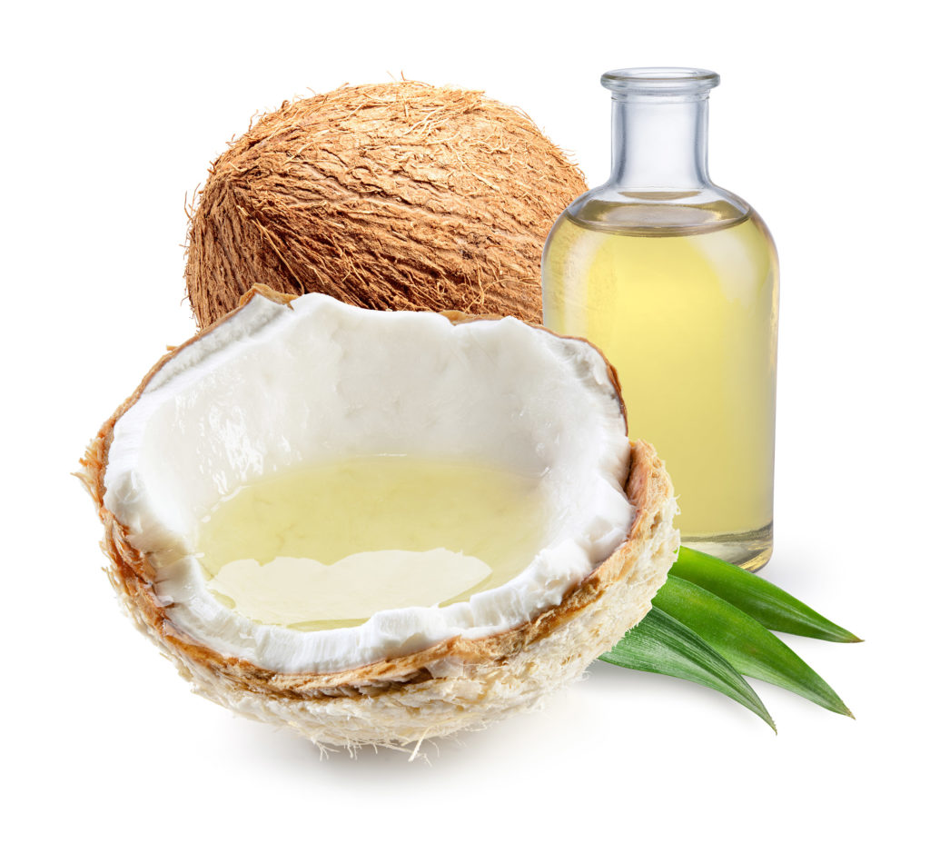 Coconut cut in half and a bottle of coconut oil