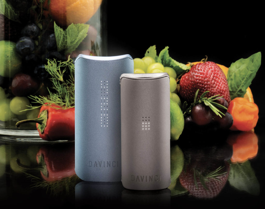 Silver and sand colored Davinci vaporizers with fruits and herbs in the background