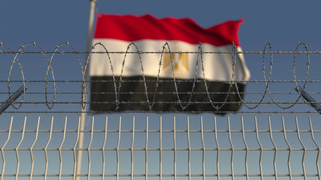 The Egyptian flag behind a barbed wire fence