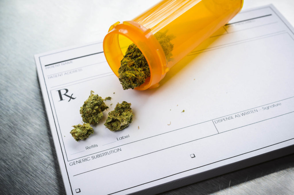 A medical cannabis form and an orange tub with cannabis spilling out