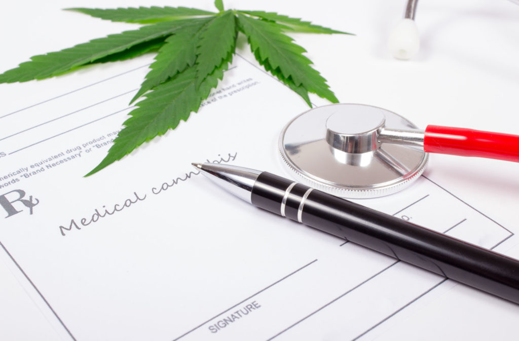 A form for medical cannabis, a pen, a stethoscope and a cannabis leaf