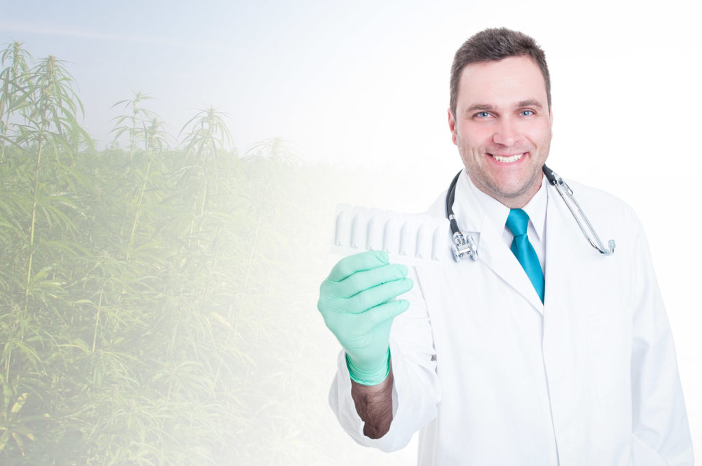 A doctor with a stethoscope around his neck holding up a white plastic container of suppositories