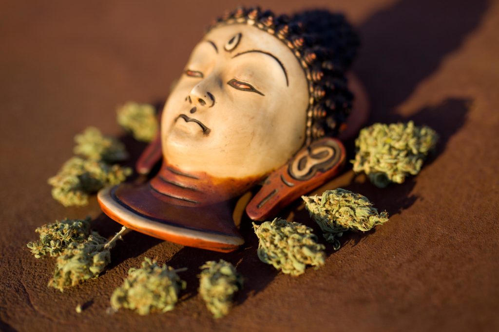 A wooden figurehead with cannabis buds placed around it