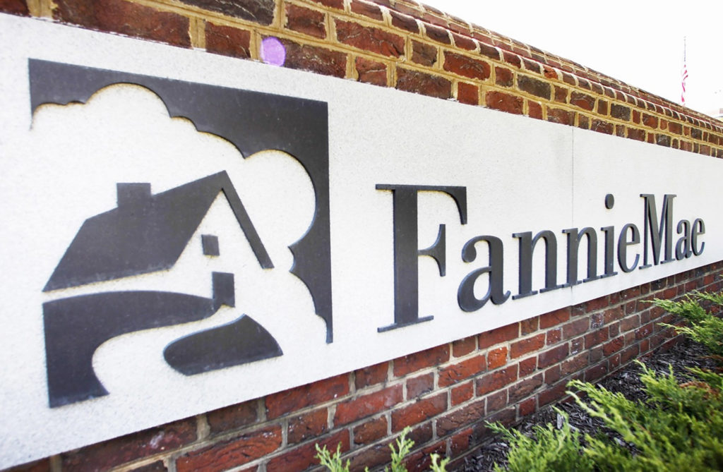 Un logo Fannie Mae noir et blanc sur un mur de briques