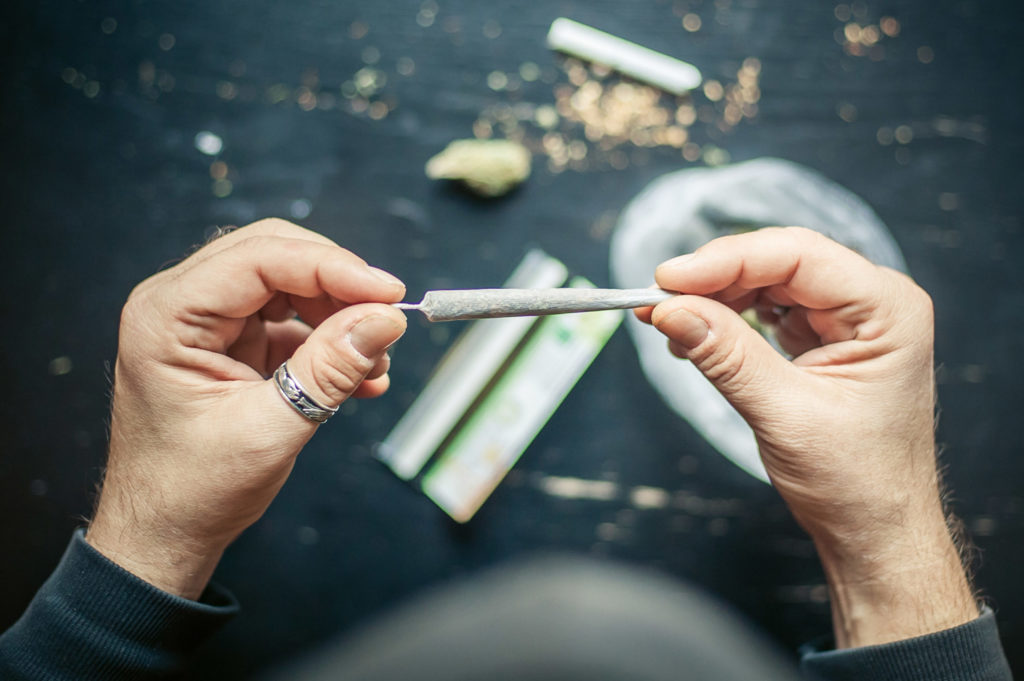 Un hombre con un anillo en su pulgar rodando una articulación