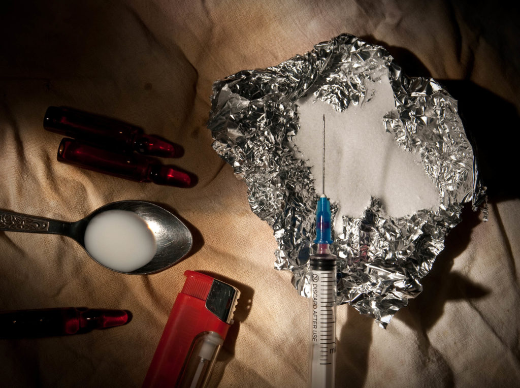 A lighter, a syringe, a piece of tin foil full of drugs and a spoon