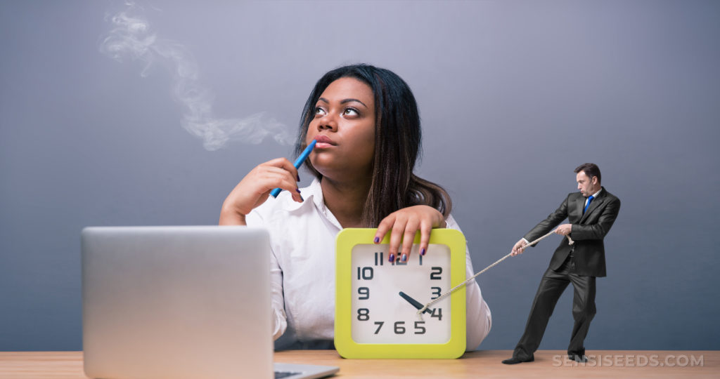 Une femme assise à un bureau à la recherche de la distance avec sa main sur une horloge