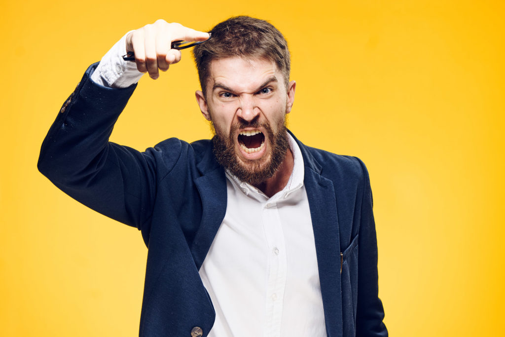 Un hombre con un traje gritando contra el fondo amarillo