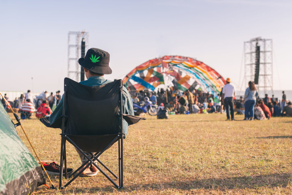 Eine Person, die einen Hut trägt, saß auf einem Campingplatz auf einem Festival