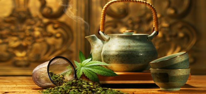 A teapot, two cups and a sieve with dried cannabis