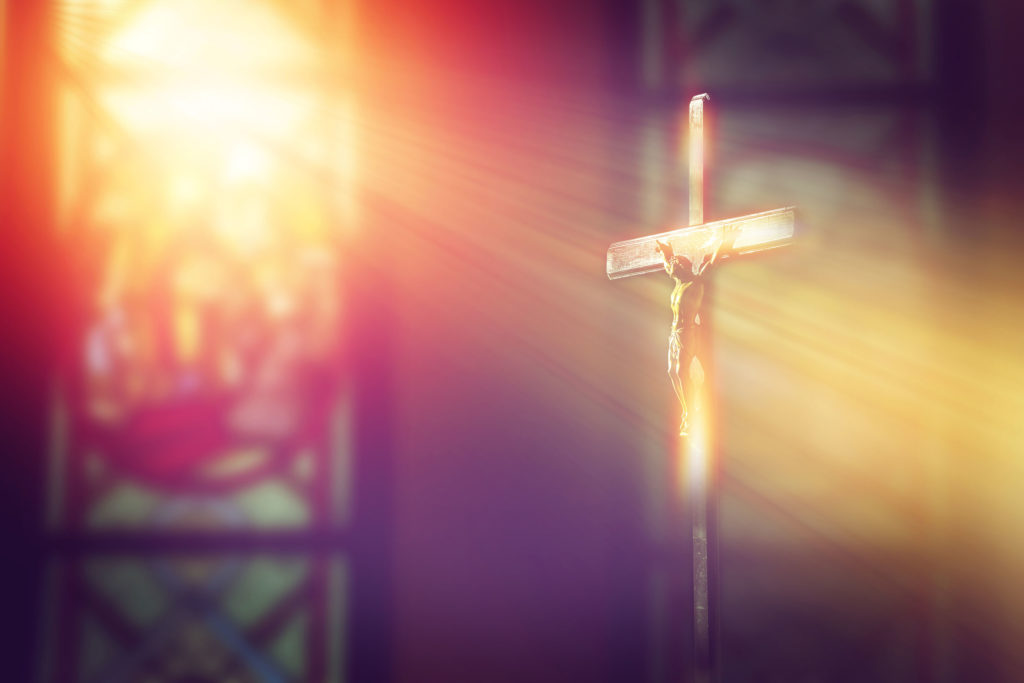 A church and a sunlight shining on the cross with Jesus Christ