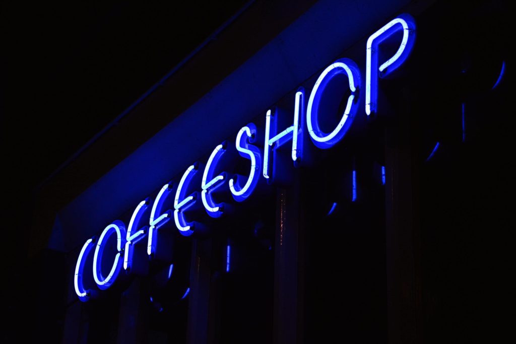 A blue neon sign that spells 'coffeeshop'