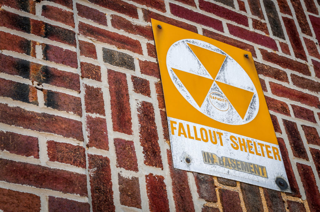 White and yellow nuclear bunker sign on the brick wall