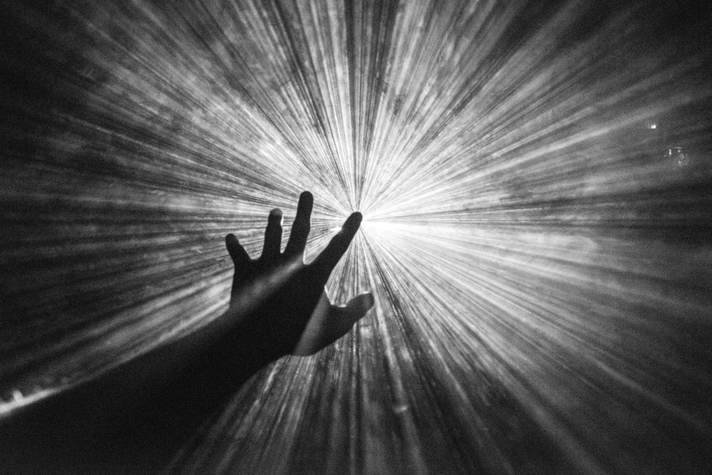 A person’s hand reaching to the light