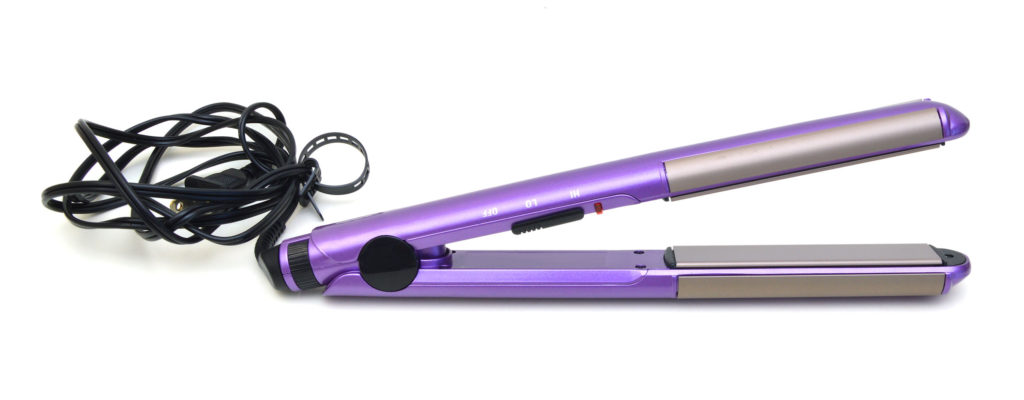 Purple hair straightener against the white background