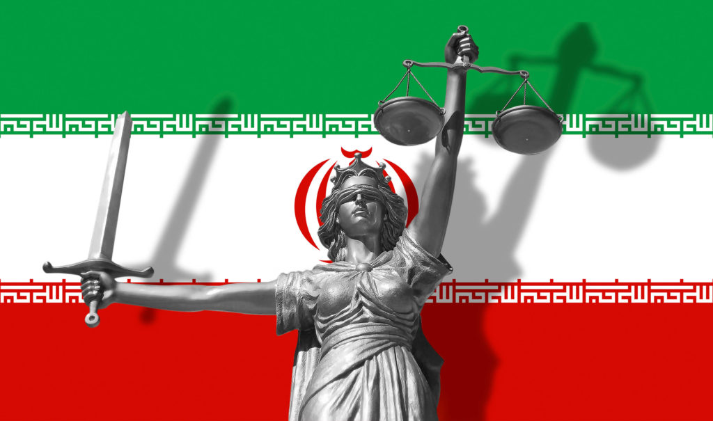 Le drapeau iranien et une statue d'argent bandés et tenant des balances et une épée