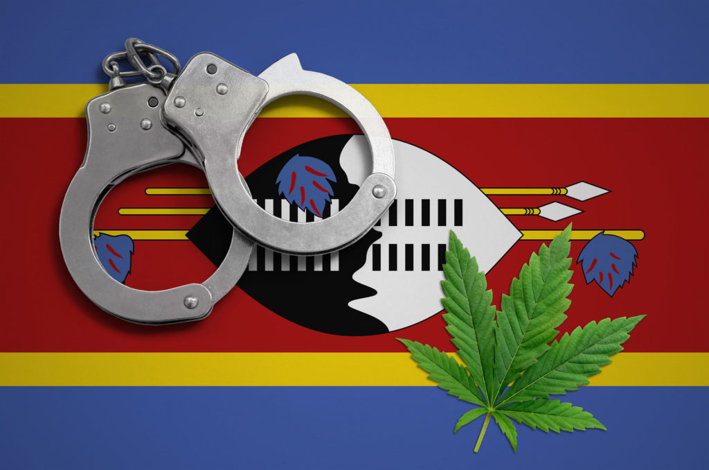 The Eswatini flag, a pair of handcuffs and a cannabis plant 