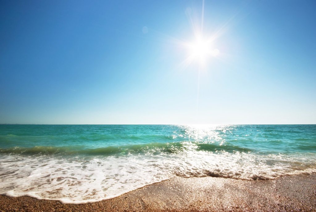 Plage et mer avec du soleil dans le ciel