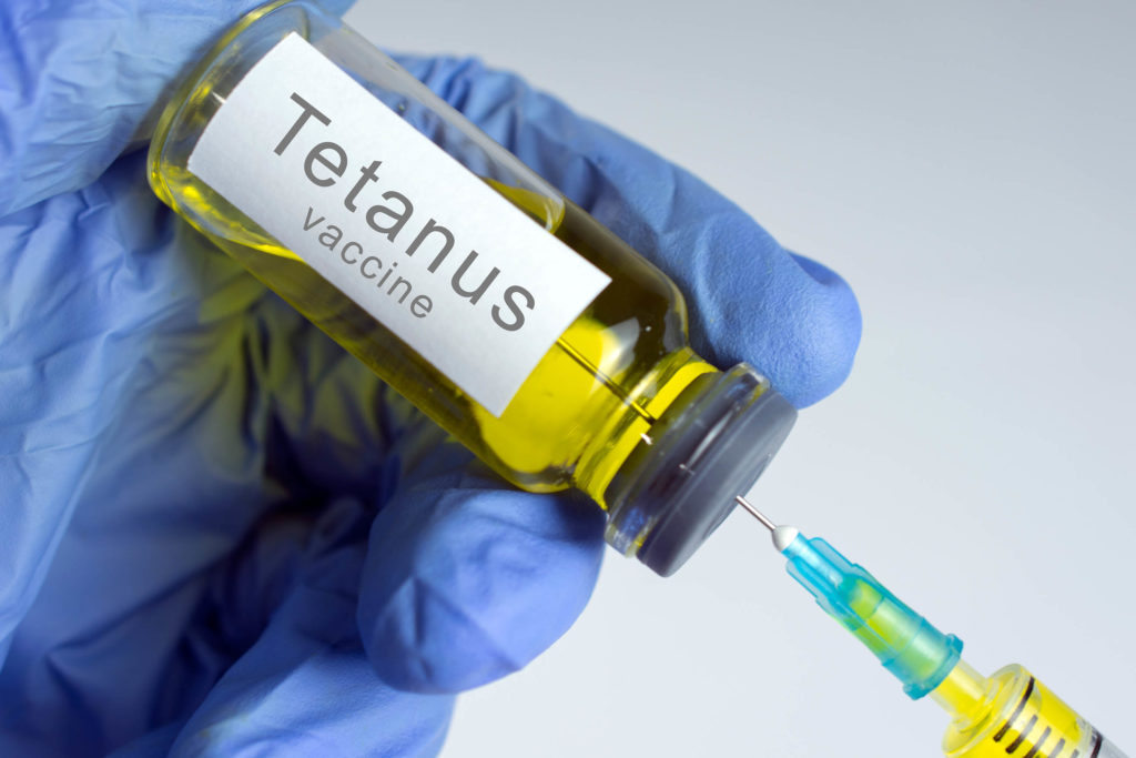 A syringe going into a vial labelled 'Tetanus vaccine'