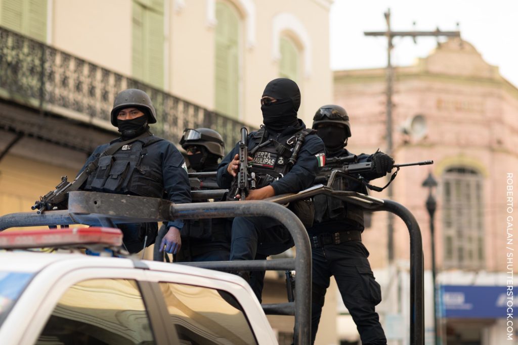 Cuatro hombres en equipo militar con pistolas