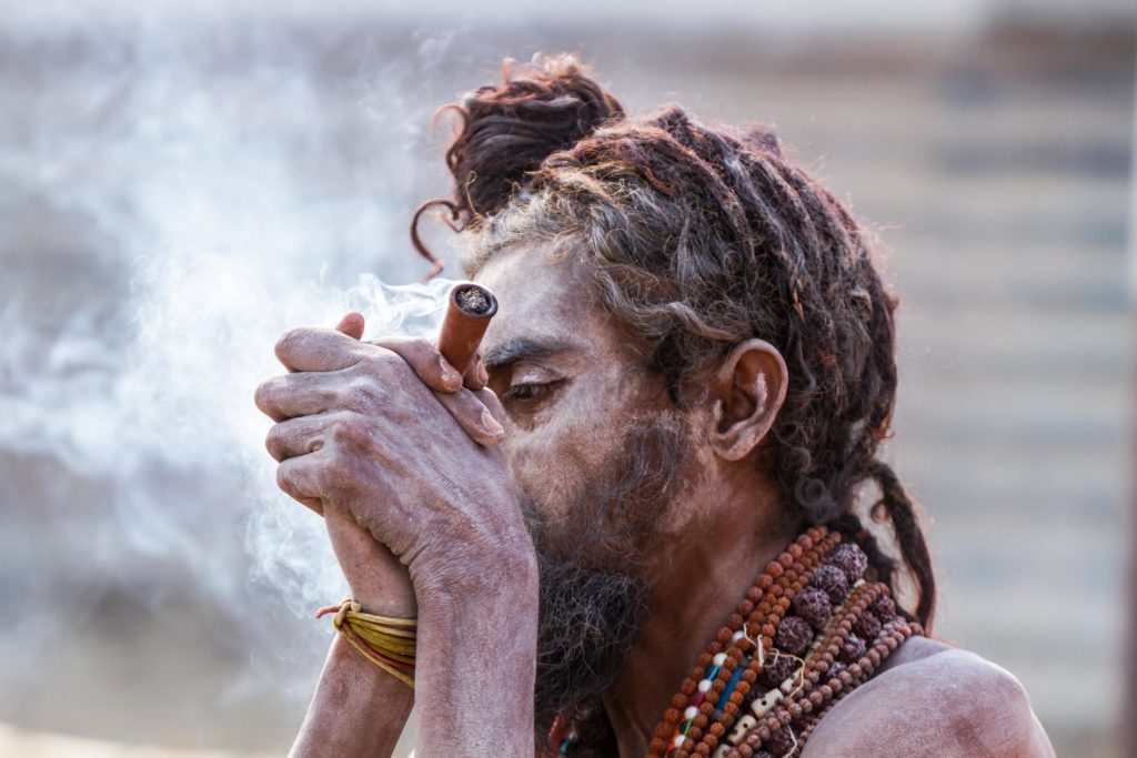 A person blowing smoke into their hands