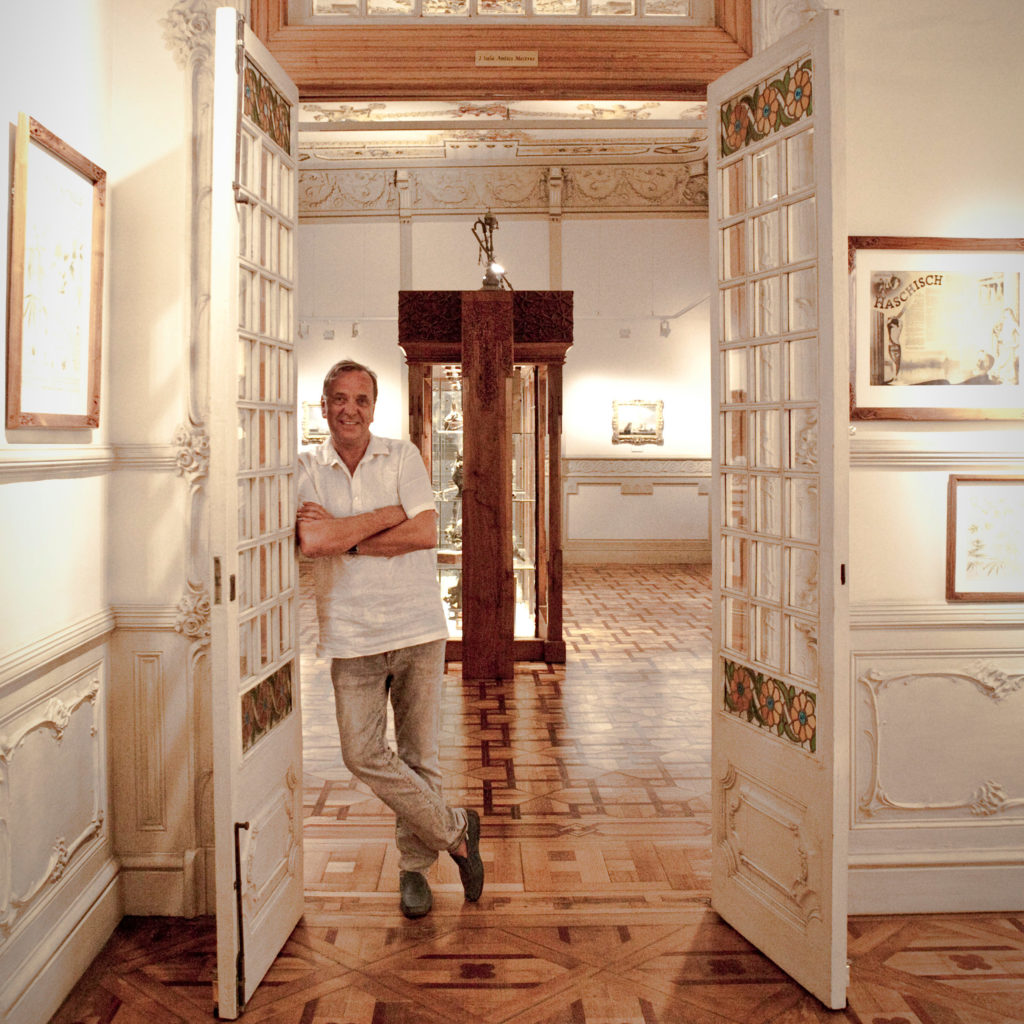 A man with his arms crossed leaning against an open doorway