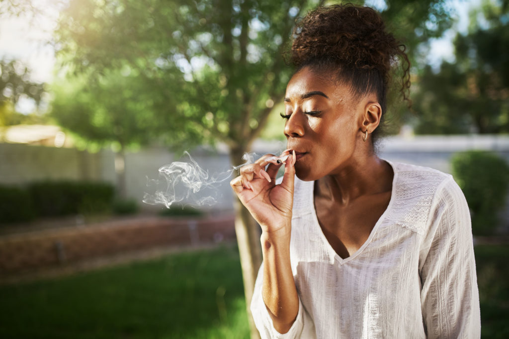 African-American woman with a bun smoking a joint