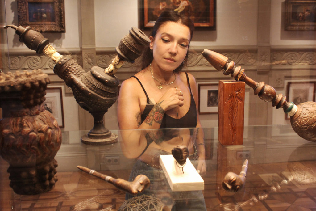 Une femme en regardant différents artefacts historiques liés au cannabis exposé dans une armoire