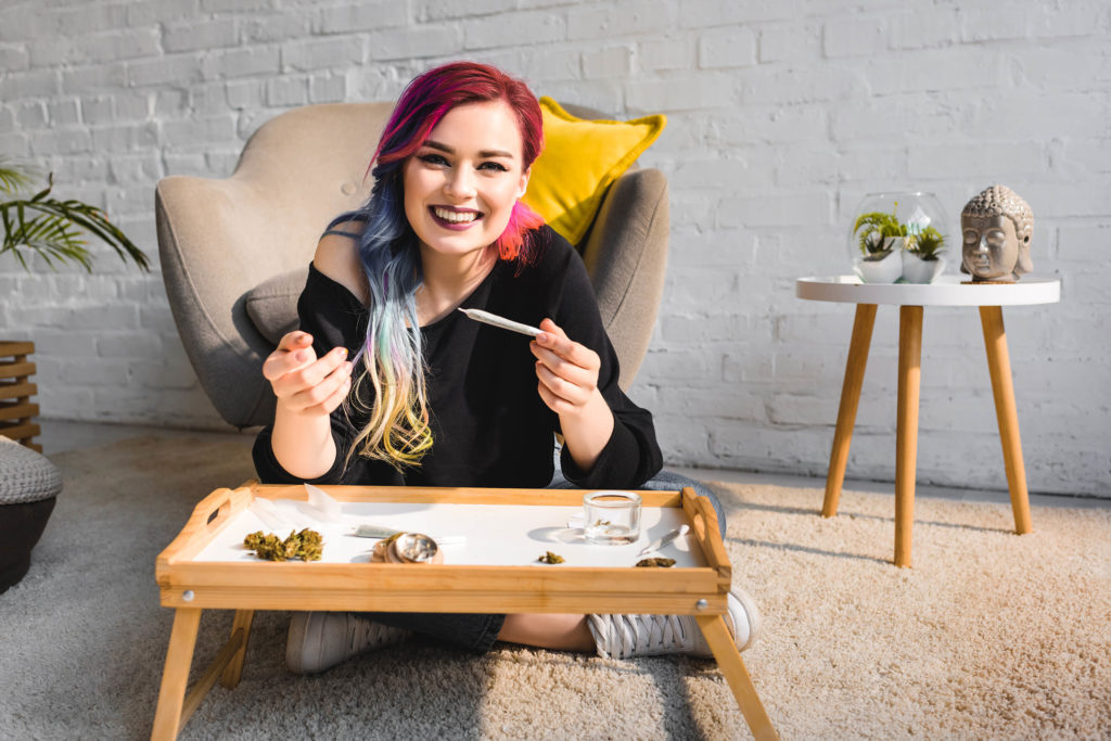 Woman with colorful hair with a joint