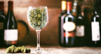 Cannabis herbal en una copa de vino con botellas de vino en el fondo