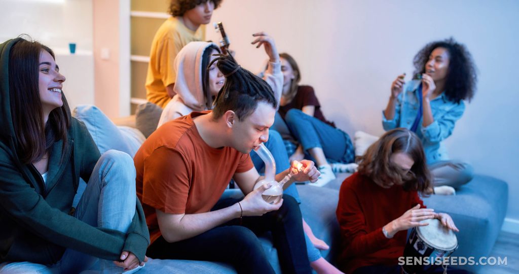 A group of young people having fun at a party and smoking a bong