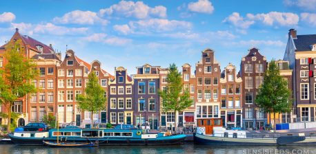 A panoramic view of downtown Amsterdam with old houses and boats in the water