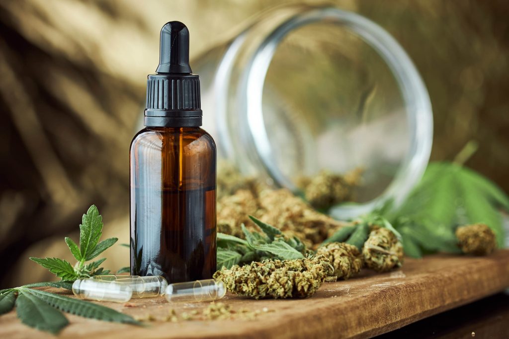 Cannabis tinctures in dark glass bottle dried with cannabis flowers and cannabis leaves