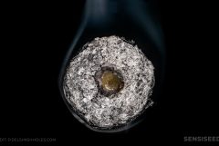 A close-up of donut joint rolled in black paper against the black the black background