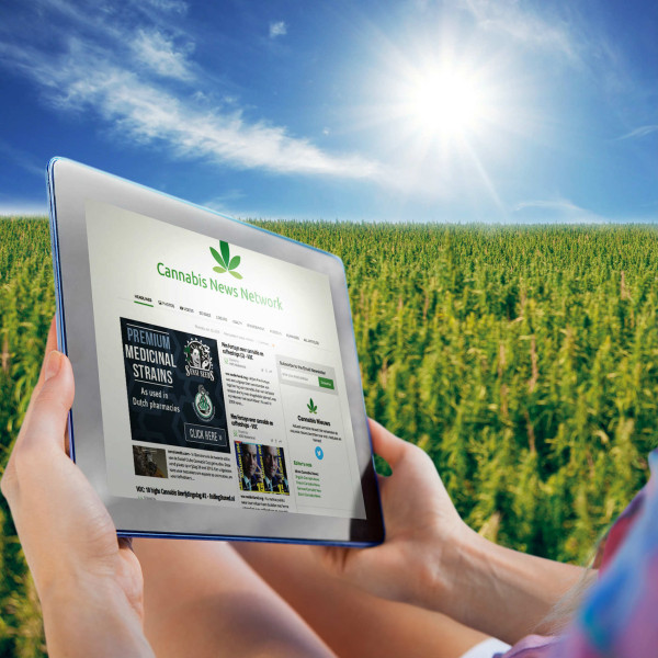 Persoon die een tablet houdt met het Netwerk van Cannabis op het scherm